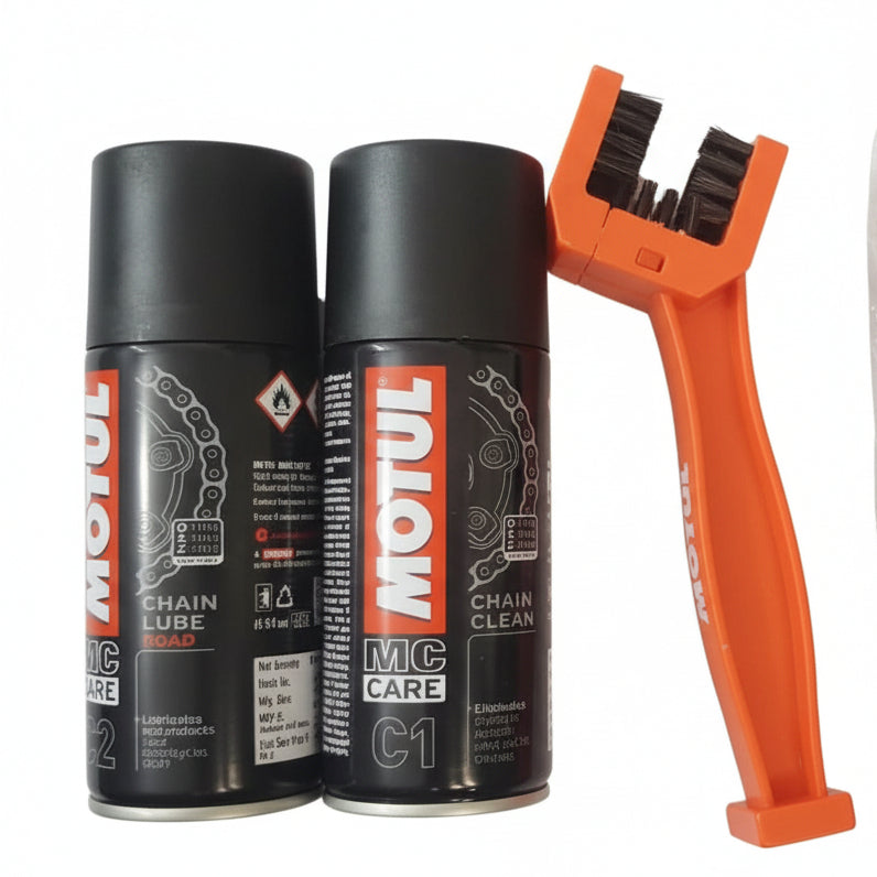 Two cans of Motul chain care products with a brush and packaging on a textured surface.